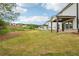 View of home's exterior, backyard, and covered patio, all set against a cloudy blue sky at 4830 Marjorie Dr, Cumming, GA 30041