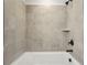 Close up of a modern bathtub with tiled walls and black fixtures at 4830 Marjorie Dr, Cumming, GA 30041