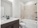 Bathroom with tiled shower, white tile tub, dark brown vanity, and brushed black fixtures at 4830 Marjorie Dr, Cumming, GA 30041