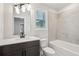 Modern bathroom with a dark wood vanity, tile backsplash, and a tiled tub at 4830 Marjorie Dr, Cumming, GA 30041