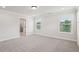 An empty bedroom featuring neutral paint colors, plush carpet, and three windows at 4830 Marjorie Dr, Cumming, GA 30041