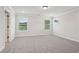 An empty bedroom featuring neutral paint colors, plush carpet, and abundant natural light at 4830 Marjorie Dr, Cumming, GA 30041