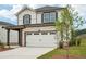 New home features a two-car garage, nicely landscaped beds and green grass at 4830 Marjorie Dr, Cumming, GA 30041