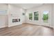 Bright living room featuring a modern fireplace, wood floors, and access to the outdoors at 4830 Marjorie Dr, Cumming, GA 30041