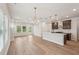 Open concept kitchen flows into the Gathering room, showcasing hardwood floors and modern fixtures at 4830 Marjorie Dr, Cumming, GA 30041
