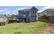 Large grassy backyard with a two-story home featuring a deck and stairs leading to a covered patio at 5153 Elkins Ln, Acworth, GA 30101