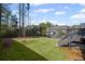 Expansive backyard with lush green grass, mature trees, and an elevated deck accessible by stairs at 5153 Elkins Ln, Acworth, GA 30101
