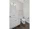 Elegant half bathroom with a white vanity, modern fixtures, and dark wood floors at 5153 Elkins Ln, Acworth, GA 30101