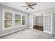 Light-filled bedroom with large windows, neutral carpet, and glass paneled French doors to an adjacent room at 5153 Elkins Ln, Acworth, GA 30101