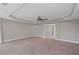 This spacious bedroom has plush carpeting, neutral decor, and a decorative tray ceiling at 5153 Elkins Ln, Acworth, GA 30101