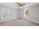 This bedroom has neutral decor, plush carpet, a ceiling fan, and two light filled windows at 5153 Elkins Ln, Acworth, GA 30101