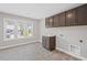 Well-lit laundry room with ample cabinet space, a sink, and multiple windows at 5153 Elkins Ln, Acworth, GA 30101