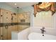 Luxurious bathroom with tiled shower, soaking tub, and elegant chandelier at 773 Pebblebrook Rd, Mableton, GA 30126