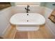 Freestanding bathtub with elegant fixtures and wood tile flooring at 773 Pebblebrook Rd, Mableton, GA 30126