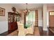 Well-lit dining room with a glass table, six chairs, a hutch and a view of the front door at 773 Pebblebrook Rd, Mableton, GA 30126