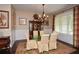 Elegant dining room featuring a glass table, six chairs, a hutch and large windows at 773 Pebblebrook Rd, Mableton, GA 30126