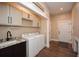 Efficient laundry room featuring modern appliances, ample cabinet storage, and stylish flooring at 773 Pebblebrook Rd, Mableton, GA 30126