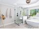 Bright bathroom featuring a large glass shower and soaking tub under a window, perfect for relaxation at 88 Cline Smith Ne Rd, Cartersville, GA 30121