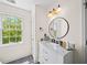 Stylish bathroom featuring marble vanity, decorative lighting, round mirror, and ample natural light at 88 Cline Smith Ne Rd, Cartersville, GA 30121