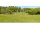 Expansive grassy field with a rustic gate in the distance, surrounded by lush trees and offering vast space and natural beauty at 88 Cline Smith Ne Rd, Cartersville, GA 30121