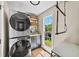 Efficient laundry room with stacked washer/dryer, storage cabinets, and a bright window at 88 Cline Smith Ne Rd, Cartersville, GA 30121
