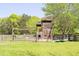 Wooden playground in expansive backyard offers a blend of recreational space and countryside allure at 88 Cline Smith Ne Rd, Cartersville, GA 30121