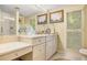 Bright bathroom vanity with double sinks, framed artwork and white cabinets at 2769 Peachtree Ne Rd # 6, Atlanta, GA 30305