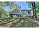 View of the rear exterior of the home with a back deck, siding, green grass and mature trees at 4640 Lambton Cir, Suwanee, GA 30024
