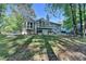 View of the rear exterior of the home with a back deck, siding, green grass and mature trees at 4640 Lambton Cir, Suwanee, GA 30024