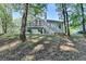 View of the rear exterior of the home with a back deck, siding, green grass and mature trees at 4640 Lambton Cir, Suwanee, GA 30024