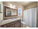 Bathroom with granite vanity, framed mirror, and shower with curtain at 925 Upper Hembree Rd, Roswell, GA 30076