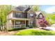 Charming two-story home featuring a welcoming front porch and lush green landscaping at 925 Upper Hembree Rd, Roswell, GA 30076