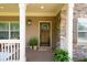 Charming front porch with a stone accent wall and views of lush landscaping at 925 Upper Hembree Rd, Roswell, GA 30076