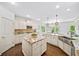 Bright kitchen features an island, stainless steel appliances, and hardwood floors at 925 Upper Hembree Rd, Roswell, GA 30076