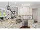 Gourmet kitchen with granite counters, stainless appliances, and an island sink overlooks the living room fireplace at 925 Upper Hembree Rd, Roswell, GA 30076