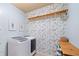 Laundry room with floral wallpaper, washer, dryer, and wooden shelving at 925 Upper Hembree Rd, Roswell, GA 30076