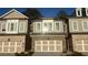 Charming townhome with a brick facade, neutral siding, and an attached garage at 102 Birch Tree Way, Cumming, GA 30040