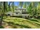 Expansive backyard view featuring a lush lawn, deck, screened porch, hot tub and mature trees, creating a private outdoor retreat at 105 Woodmeade Nw Way, Marietta, GA 30064
