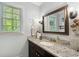 Chic bathroom with granite countertops, a decorative mirror, and stylish lighting fixtures at 105 Woodmeade Nw Way, Marietta, GA 30064