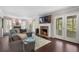 Spacious living room with a brick fireplace, hardwood floors, and French doors leading to the screened porch at 105 Woodmeade Nw Way, Marietta, GA 30064