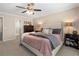 Well-lit main bedroom with neutral decor, a ceiling fan, and large dresser at 105 Woodmeade Nw Way, Marietta, GA 30064