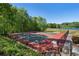 Community tennis courts surrounded by trees and a lake view, offering a recreational space at 105 Woodmeade Nw Way, Marietta, GA 30064