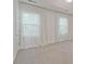 Bright bedroom with neutral carpet and large windows dressed with white curtains at 1971 Sterling Oaks Cir, Brookhaven, GA 30319