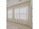 Spacious bedroom with neutral carpet and large windows dressed with white curtains at 1971 Sterling Oaks Cir, Brookhaven, GA 30319