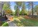 Serene backyard featuring a wooden deck, lush lawn, and mature trees at 744 Edgewater Nw Ln, Kennesaw, GA 30144