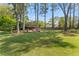 Expansive backyard with mature trees, a fire pit area, and lush green grass at 744 Edgewater Nw Ln, Kennesaw, GA 30144
