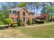 Traditional brick home with a manicured lawn, mature trees, and a welcoming entrance at 744 Edgewater Nw Ln, Kennesaw, GA 30144