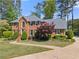 Stately brick home with lush landscaping, mature trees, and a curved walkway at 744 Edgewater Nw Ln, Kennesaw, GA 30144