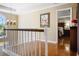 Hallway showcasing wood flooring, white railing and staircase, and chandelier lighting at 744 Edgewater Nw Ln, Kennesaw, GA 30144