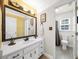 Bright bathroom featuring a large mirror, white cabinetry, and a separate toilet area at 815 Connell Ln, Lawrenceville, GA 30044